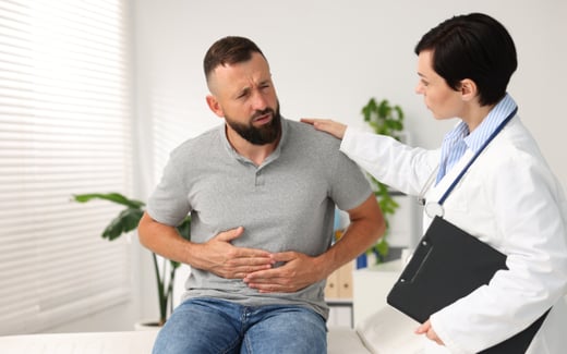 A man discussing stomach discomfort with his provider. 