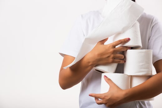 Image of person holding many rolls of toilet paper